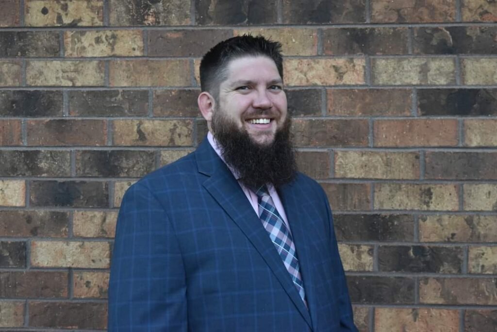 Picture of Jeremy Gothard standing in front of a brick wall.